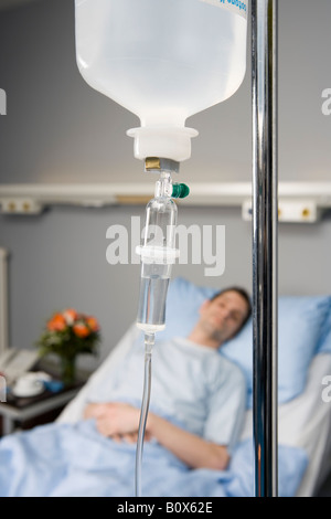 Ein Tropf und ein Patient im Hintergrund Stockfoto