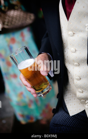 Ein Mann hält ein Getränk bei einer Hochzeit Stockfoto