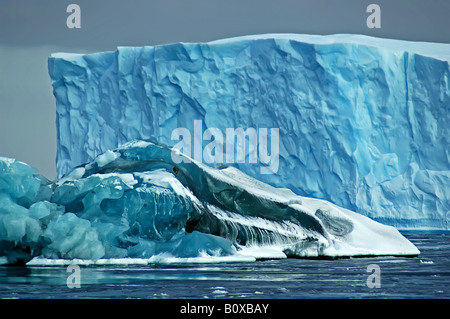 Ein größeren blauen Eisberg im Hintergrund verbirgt sich teilweise durch eine kleinere so genannte schwarze Eisberg im Vordergrund, das letztere par Stockfoto