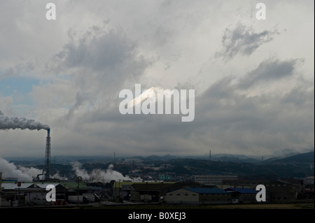 Japan. Ein Blick auf den Fuji durch die Wolken, der über der düsteren Industrielandschaft außerhalb Tokios thront, vom shinkansen oder vom Hochgeschwindigkeitszug aus gesehen Stockfoto