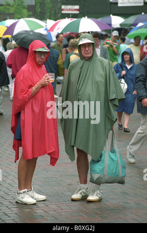 Wet Tennis Fans in Wimbledon. Regenwetter regnet Großbritannien Großbritannien England Englisch Klima Umhang Kleidung Sommer Stockfoto