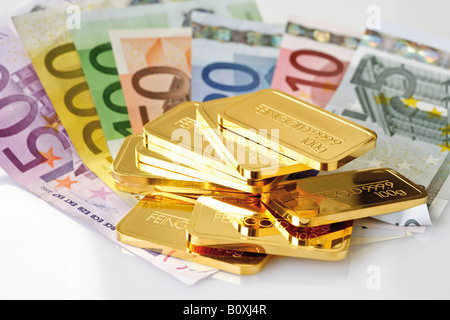 Goldbarren und Euro-Banknoten Stockfoto