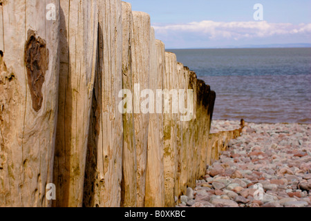 Wellenbrecher Beiträge führender ins Meer auf einem Kiesstrand in Porlock, Exmoor, Somerset Stockfoto