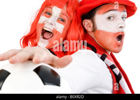 Österreichischen und schweizerischen Fußball-Fans, EURO 2008. Ein Mann und eine Frau Rücken an Rücken in Hochstimmung mit Fußball Stockfoto