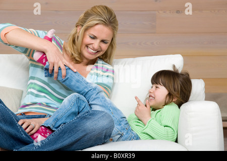 Mutter und Tochter (6-7) auf Sofa sitzen, Porträt Stockfoto