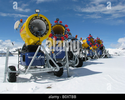 Linie von Schneekanonen (Beschneiungsanlagen) in der verschneiten Landschaft unter blauem Himmel, Italien, Suedtirol, Sarntaler, Reinswald Stockfoto