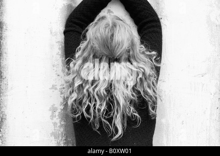 Mädchen mit langen blonden Haaren vor einer weißen Wand, Deutschland Stockfoto