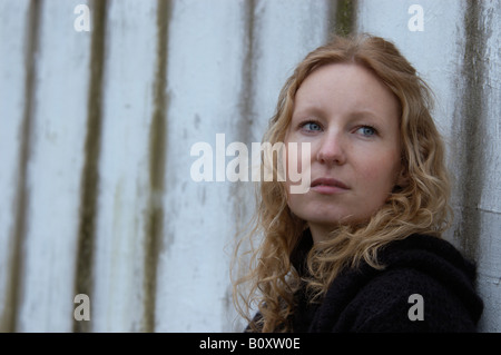 Porträt einer fair - dunkelhaarige Frau mit lockigen Haaren vor einer Wand Stockfoto