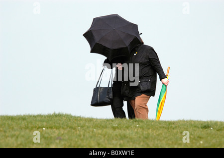 Mensch unter einem schwarzen Regenschirm bei Sturm Stockfoto