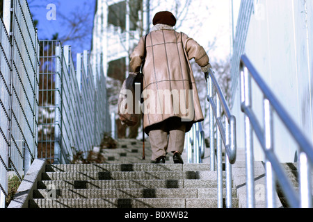 alte Frau gehen die Treppe nach oben Stockfoto