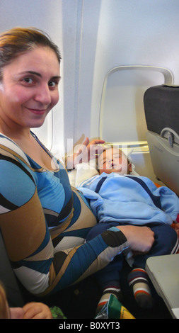 Mutter in einem Flugzeug mit ihrem schlafenden Baby auf seinen Schoß, Spanien, Palma Stockfoto