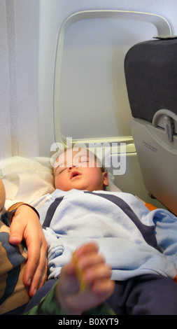 Schlafendes Baby in einem Flugzeug auf dem Schoß seiner Mutter, Spanien, Palma Stockfoto