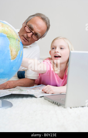Großvater und Enkelin (8-9) Blick auf Globus, Stockfoto