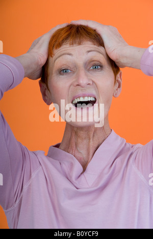 überrascht, ältere Frau, mit den Händen auf den Kopf Stockfoto