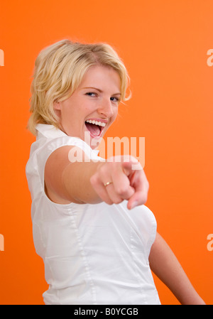 junge Frau zeigt auf etwas Stockfoto