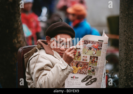 Mann liest Zeitung, China, Chengdu Stockfoto