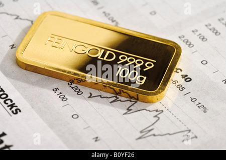 Goldbarren und Finanzzeitung Stockfoto