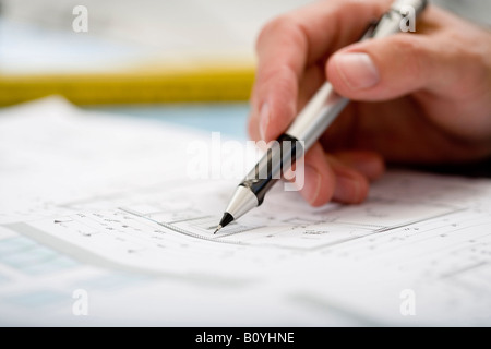 Hand des Mannes zeigte auf Blaupause mit Stift Stockfoto