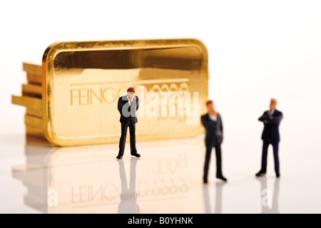 Geschäftsmann Figuren im Hintergrund gold bars Stockfoto