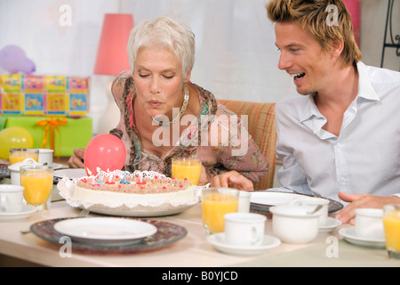 Frau bläst Kerze auf der Torte, Porträt Stockfoto