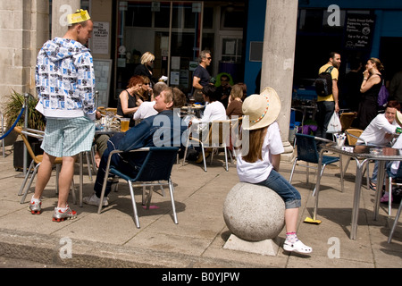 gemischte Gruppe sitzt vor einem Pub auf Brighton seafront Stockfoto