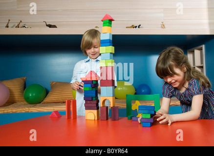 Jungen (8-9) und Mädchen (6-7) spielen Bausteine, portrait Stockfoto