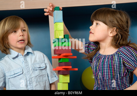 Jungen (8-9) und Mädchen (6-7) spielen Bausteine, portrait Stockfoto