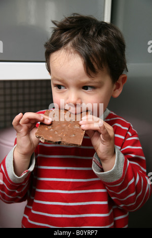 Tot auf Küchenseite ein großes Stück Schokolade essen sitzen ganz zu halten Stockfoto