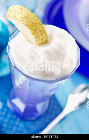 Zitronensorbet serviert eisgekühlte in blauem Glas mit Birne Scheibe am Tischset in blau, Essen Stockfoto