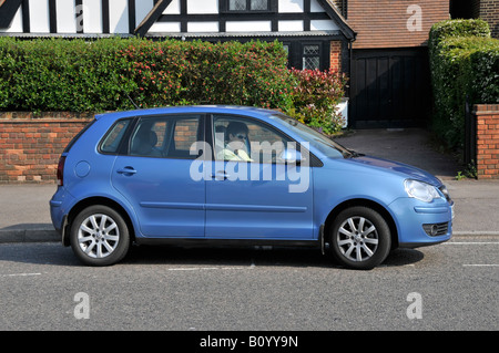 Rentnerin fährt einen Volkswagen VW Polo Auto wegziehen Von einer Parkbucht Stockfoto