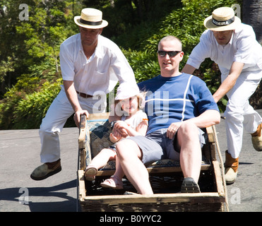 dh Wicker Korb Touristische Rodel MONTE FUNCHAL MADEIRA PORTUGAL man Mädchen Kinder auf Fahrt Schlitten Kind Stockfoto