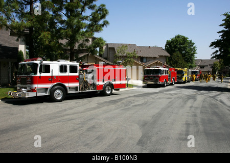 Feuerwehrleute, die Rückkehr in ihre Feuerwehrfahrzeuge oder Feuerwehrautos Stockfoto