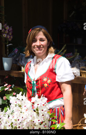 dh Blumenstand FUNCHAL MADEIRA Blumenverkäufer in traditionellem Kostüm Mädchengeschäft Verkäufer Markt Vender Frau Blumen Stallholder portugal Stockfoto