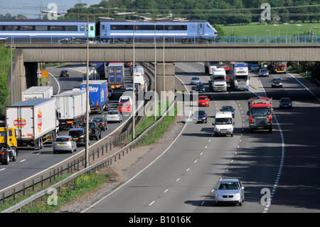 Transport Choice M25 Autobahn Stau langsam Verkehr Stau beobachten schnelle Personenzug Eisenbahnbrücke Kreuzung 28 Brentwood Essex England UK Stockfoto