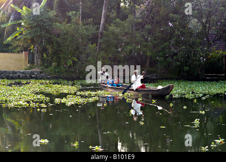 Indien KERALA zwei indische Männer und drei jungen, die ihre hölzernen Kanus über die Kanäle in den Backwaters von Kerala Rudern Stockfoto