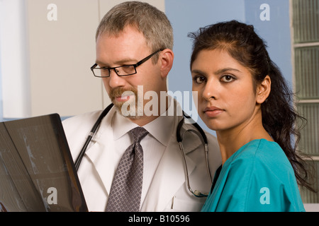 Arzt und Krankenschwester Röntgenaufnahmen des Patienten zu betrachten. Stockfoto