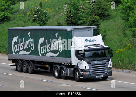 Scania Lkw Brauerei Lkw Lkw mit beweglichen supply chain Lieferung trailer Werbung der Carlsberg Logo auf de Autobahn England fahren Stockfoto