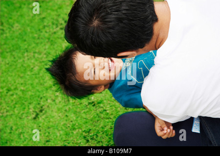 Vater Holding Sohn im park Stockfoto