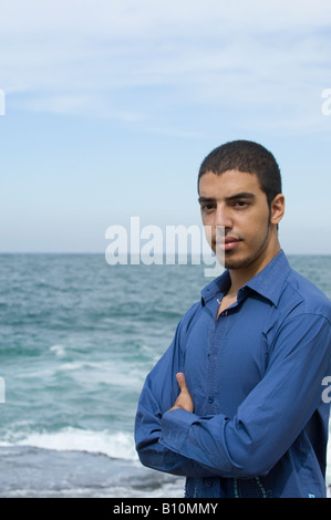 Ethnische Jüngling Arme verschränkt am Meer mit textfreiraum für text Stockfoto