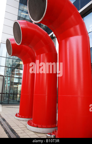 Lüftungsöffnungen als drei große rote Röhren in einem modernen Gebäude Stockfoto