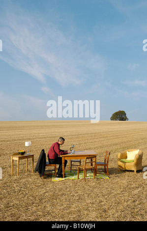 Mann sitzt am Tisch im Zimmer lesen und arbeiten im freien Stockfoto