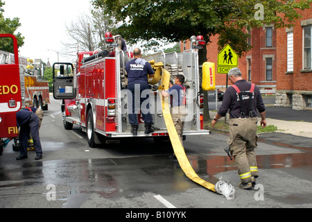 Eine Feuerwehr bereinigen, nachdem ein Haus Feuer in der Innenstadt von Toledo Ohio Stockfoto