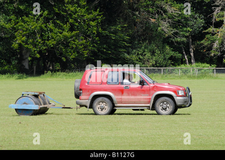 Allradantrieb zieht eine schwere Walze um glätten Sie den Boden vor einem Polospiel Stockfoto