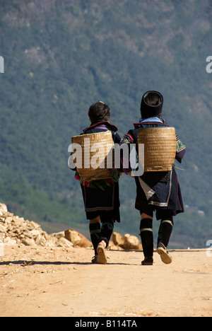 Zwei Black Hmong Frauen tragen Körbe Katze Cat Tal in der Nähe von Sapa Nordvietnam Stockfoto