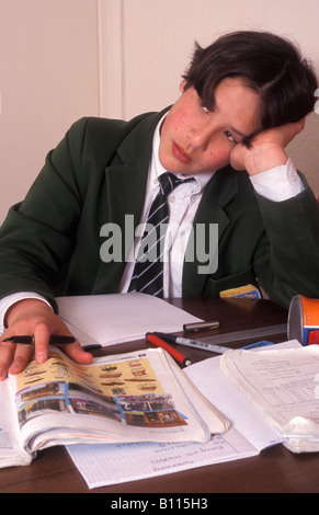 betonte junge in intelligente Schuluniform Hausaufgaben Stockfoto