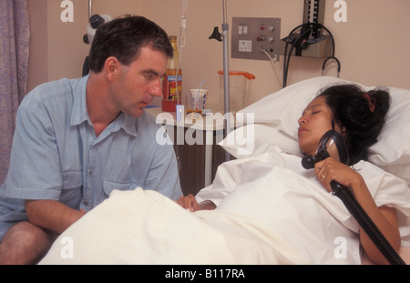 Partner unterstützt hispanische junge Frau in der Arbeit im Krankenhaus Stockfoto