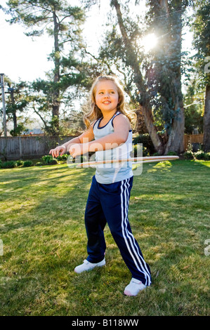 Kaukasische Mädchen spielt in einem Hinterhof Hula-Hoop Stockfoto