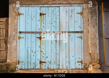 Eine alte blaue Delapitated Tür zu einem kleinen Dorfladen in Asien. Stockfoto