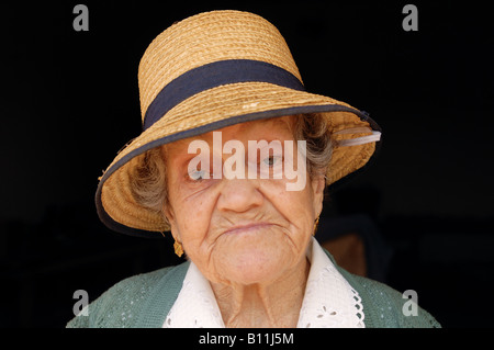 Porträt einer Frau mit einem für die Region typischen Strohhut aus der Algarve. Korbweide artesanato ist handgefertigt aus Roggenstroh, eine Tradition der portugiesischen Vorfahren Stockfoto