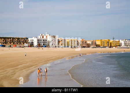 Ein paar Urlauber genießen einen Spaziergang am Strand von Barbate - Playa de Barbate - in der späten Nachmittagssonne. Playa de Barbate, Barbate, Cádiz, Andalucía, Spanien. Stockfoto